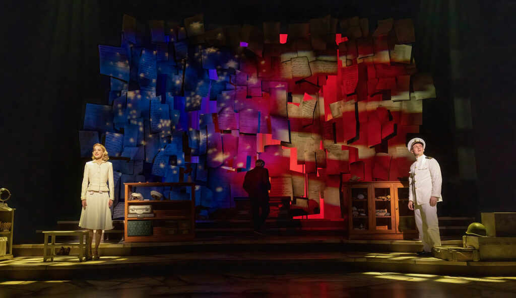 a man and woman performing on stage in front of an american flag