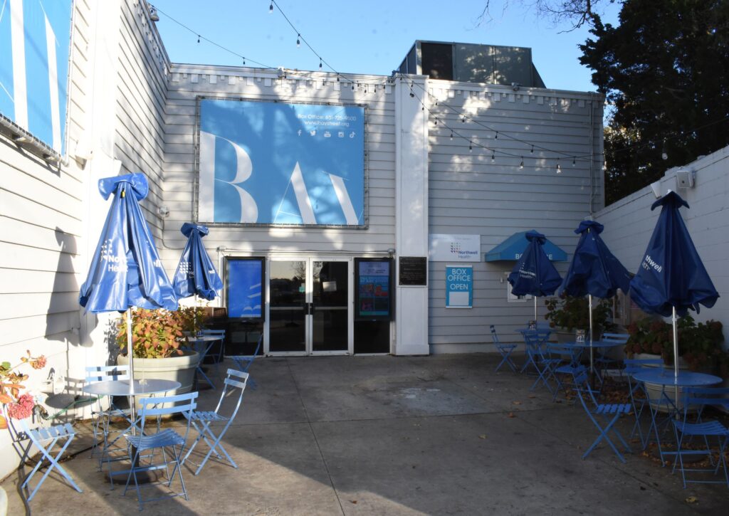 courtyard outside the theater with banners and tables with umbrellas