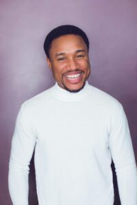 Headshot of Sharief Johnson grinning for the camera.