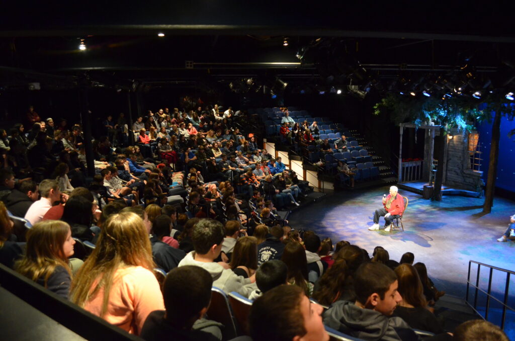 full audience surrounding man on stage